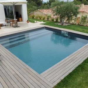 Une piscine carrée Piscinelle face à une maison moderne